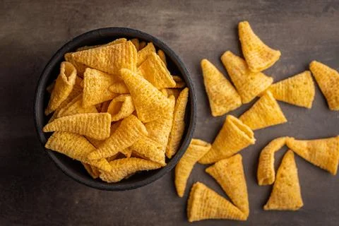 Bugles snack. Cone corn chips in bowl on kitchen table. Stock Photos