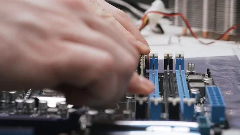 Build a computer, close-up view, 4K. A male service worker installs the RAM Stock Footage 105075150