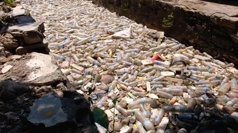 Build up plastic water bottles and rubbish trash stopped by barrier in canal in Video stock 337965430