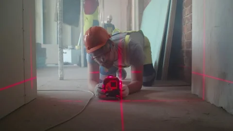 Builder adjusting laser level on floor before measure Stock Footage 133639627