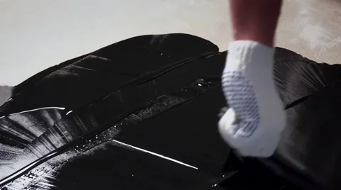 Builder aligns bitumen mastic on the sur... | Stock Video | Pond5