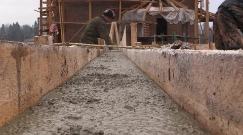 Builder aligns the horizontal level of the concrete with a trowel in formwork Stock Footage 57321905