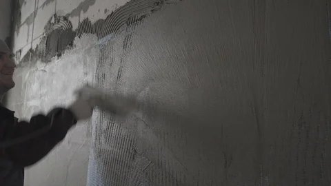 Builder aligns the surface on the grid with putty Stock Footage 101663206