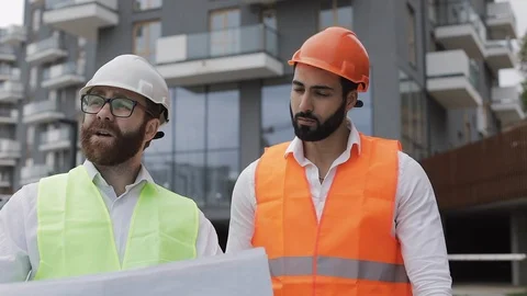 The builder and architect man are discussing the construction plan of the modern Stock Footage 109632392