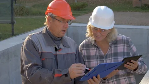 Builder And Client In Helmet Discuss Construction According To Plan Project Stock Footage 98868870