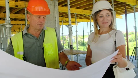Builder and engineer hold technical documentation for project Stock Footage 317628079