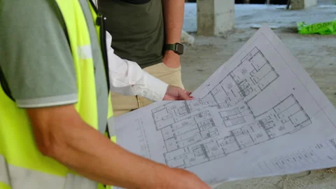 Builder and engineer study large floor plan with room layout Stock Footage 317609372