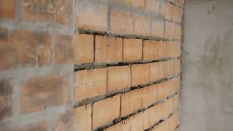 The Builder applies cement mortar to the brick wall. Video stock 133718498