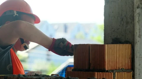 Builder applies mortar to bricks assessing density of structure Video stock 317605931