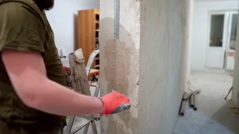 The builder applies plaster to the profile Stock Footage 169624898