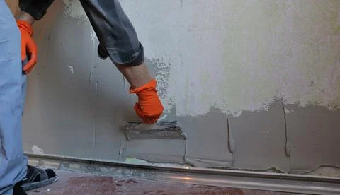 Builder applies plaster on wall surface Stock Photos