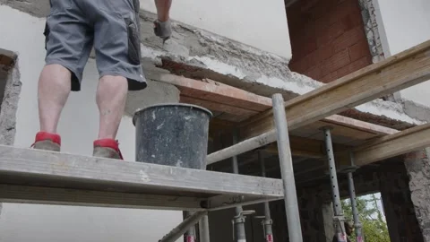 Builder applying mortar with trowel at house construction site Stock Footage 244477066
