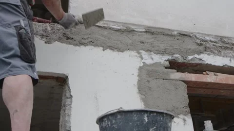 Builder applying mortar with trowel at house construction site Stock Footage 244477336