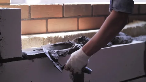 Builder applying mortar to white brick Stock Footage 255300217