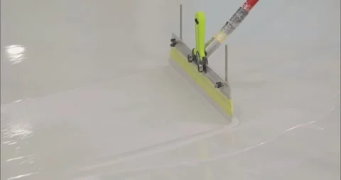 A builder is applying polymer floors using Scraper Float. A builder distributes Vídeo Stock 276610857