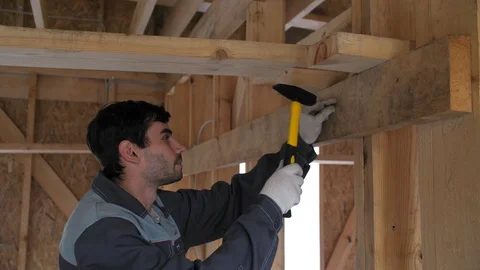 The builder beats with the hammer to himself a finger. Construction of the house 動画素材 103219051