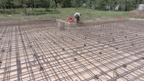 Builder binds the metal structure for reinforced concrete with wire Stock Footage 315654979