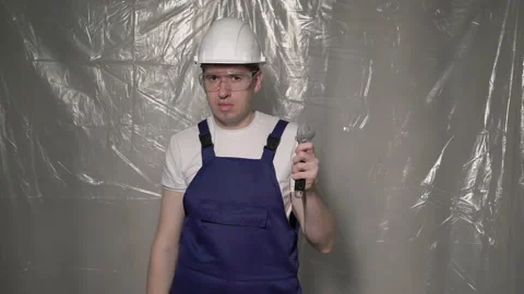 Builder in blue overalls and white hard hat helmet and glasses with wrench. Stock Footage 171144194