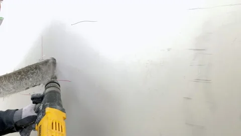 The builder breaks concrete at a construction site Stockbeeldmateriaal 155359087