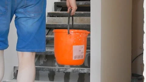 A builder with buckets rises and goes downstairs in a house under construction Stock Footage 100770230