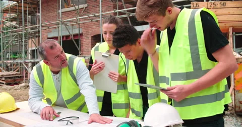 Builder On Building Site Discussing Work With Apprentices Stock Footage 56221365