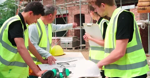 Builder On Building Site Discussing Work With Apprentices Stock Footage 56221390
