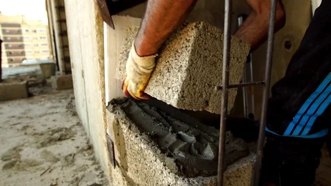 The Builder Builds A Concrete Wall With A Cement Block. Stockbeeldmateriaal 93587266