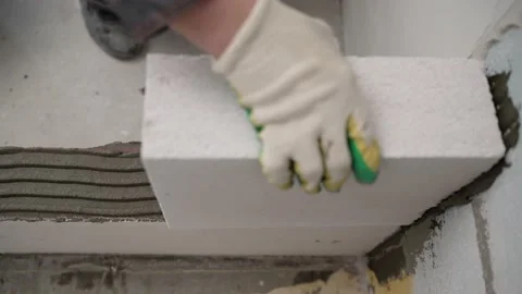 Builder builds a concrete wall made of cement blocks on the construction site of Video stock 174201909