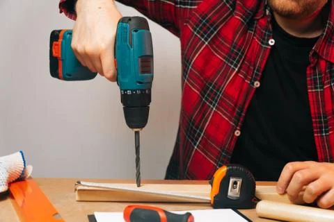 The builder is a Caucasian man with a beard twisting iron nails. The concept  Stock Photos