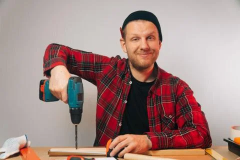 The builder is a Caucasian man with a beard twisting iron nails. The concept  Stock Photos