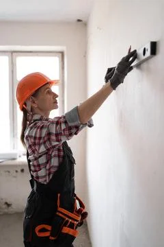 Builder checking wall using spirit level, during building construction or h.. 写真素材