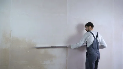 Builder checks evenness of freshly built wall with bubble level with free space Stock Footage 102887298
