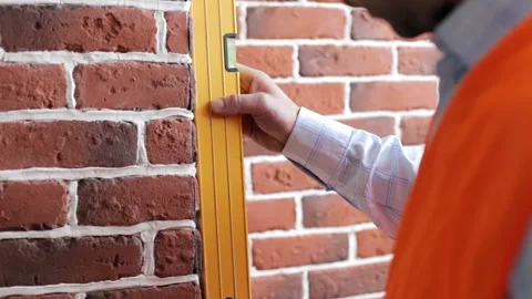 The builder checks the level of the wall Stock Footage 87379801