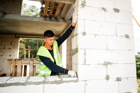Builder checks vertical level, wall alignment, site measurement, constructi.. 스톡 사진