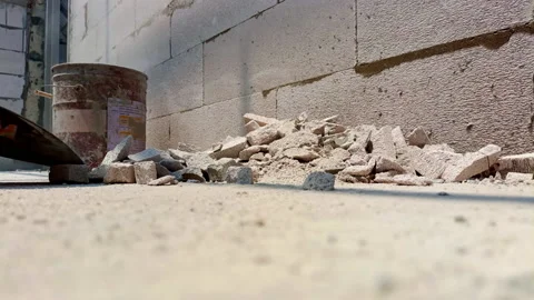 Builder cleaning room after demolition jobs from old concrete and bricks by Stock Footage 196139912