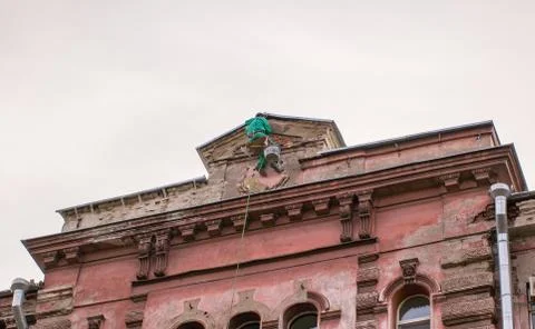 Builder-climber hanging on the top of the facade a building Stock Photos