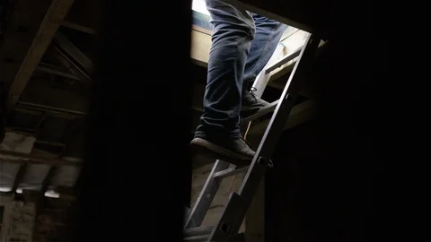 Builder climbs down a ladder from a roof in a derelict building Vídeos de archivo 110787264