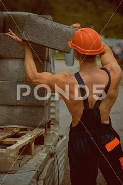 Builder concept. Builder unload truck. Builder in working uniform. Builder carry Stock Photos