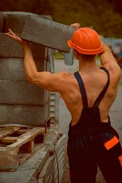 Builder concept. Builder unload truck. Builder in working uniform. Builder carry Foto stock