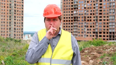 Builder on construction building site making a shushing gesture raising his Stock Footage 111866988