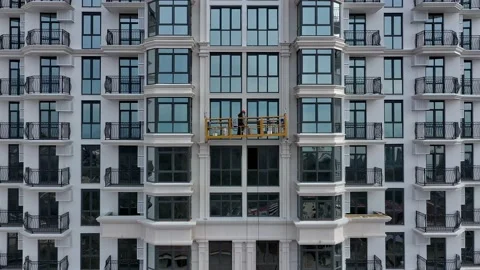 Builder on a construction elevator work at a building under construction with Vidéo 147977399