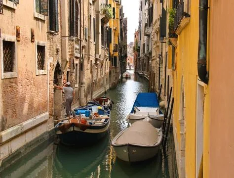 Builder with construction materials in  boat is worth innarrow channel near t Stock Photos