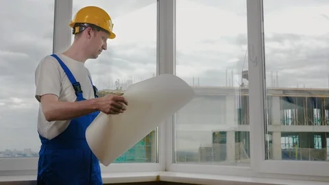 Builder at construction site with blueprint. Stock-Footage 115984415