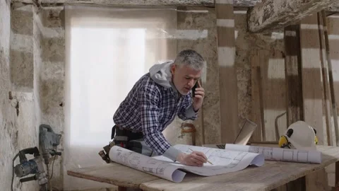 Builder construction worker on a residential indoor renovation site reviews.. Stock Footage 307839199