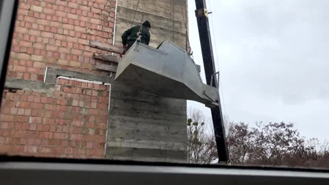 A builder in a container for supplying concrete mortar, violating safety Stock Footage 263238557