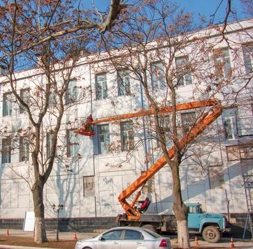 Builder in a crane basket repairs the coating of a metal structure on the w.. Stock Photos