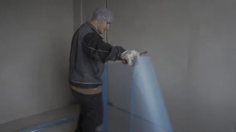 Builder cuts off a piece of the grid in the apartment where repairs are being Stock Footage 101661592