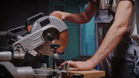 A builder cuts a wooden board on a table circular saw in construction studio Stock Footage 170502038