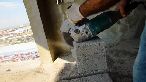 Builder of cutting heavy duty stone, angle grinder. Stockbeeldmateriaal 93587111