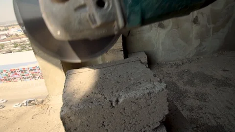 Builder of cutting heavy duty stone, angle grinder. Stockbeeldmateriaal 93587206